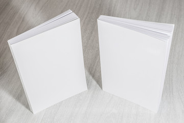 Real 3D paperback white books on a wood background