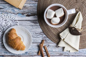 Hot chocolate and marshmallows with croissant, top view
