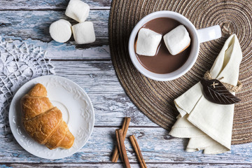 Hot chocolate and marshmallows with croissant, top view