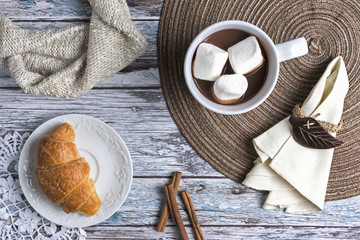 Hot chocolate and marshmallows with croissant, top view