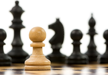 White pawn against a superiority of black chess pieces