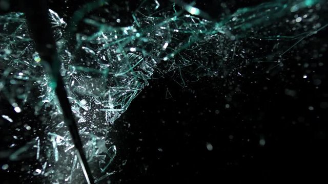 Plate Glass on Black shattering in slow motion - window smashed by baton -