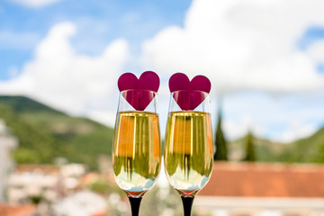     two glasses of champagne and red hearts 