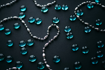 silver beads and blue glass pebbles on a black background. The Concept Of Valentine's Day