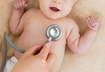 Dostor with stethoscope checking baby