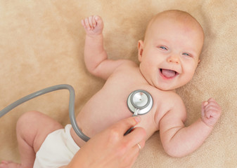 Doctor checking smiling babies heart © Kaspars Grinvalds