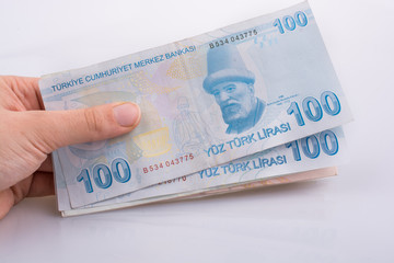 Hand holding 100 Turksh Lira banknotes  in hand