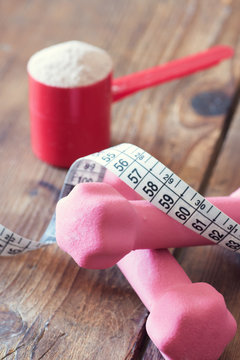 weight loss concept - with tape measure whey powder and pink dumbbells