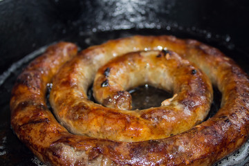 baked homemade sausage close up in a black background