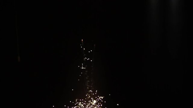 Gold sparks rising exploding over black background in slow motion