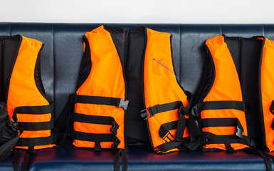 Travel to The Sea Safety. Group of Orange Life Vests on Blue Seat in Speed Boat for Tourist to use...