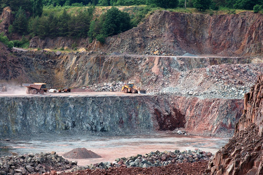 View into a quarry mine with dumper truck and earthmover