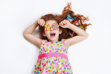Laughing child with candy lollipop eyes in white background.