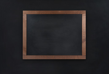 Empty blackboard (chalkboard) on black wall