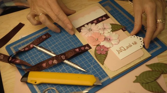 woman hands making a scrapbooking holiday gift postcard
