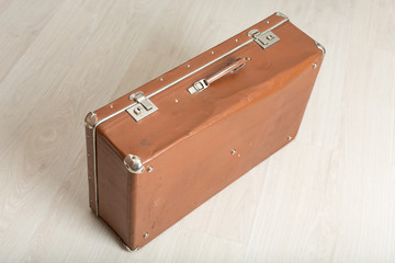 Old suitcase on light background