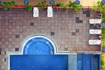 Sun-beds and swimming pool to relax on top view