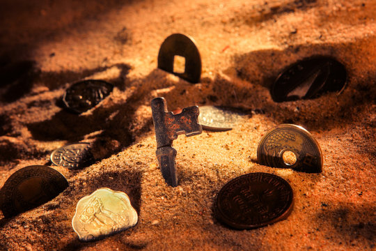 Keys And Coins Buried In The Sand