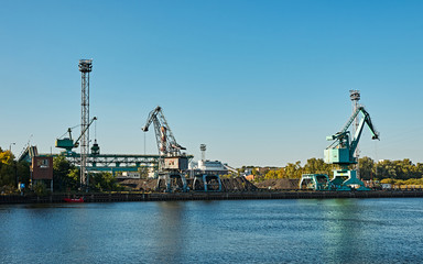 Obraz premium cranes on the quay of the river under blue sky