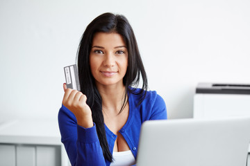 Young woman with a credit card and laptop