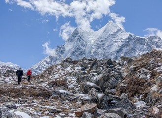 Tourists walk on a trail in the valley Chhukung against peak Ama Dablam (6814 m) from the valley of...