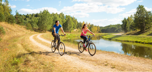 Young Happy Couple Riding Bicycles by the River. Healthy Lifestyle Concept.  - 134968647