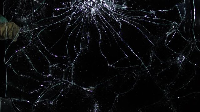 Plate glass window broken by blunt weapon isolated on black in slo-mo