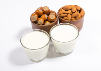 Glass of hazelnut milk and almond isolated on white background.