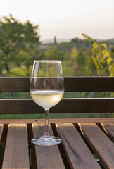 Glass of white wine on wooden table with picturesque view