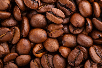 Naklejka premium roasted coffee beans isolated in white background. Roasted coffee beans background close up. Coffee beans pile from top on white background with copy space for text. Good morning.