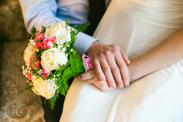 Obraz na płótnie Canvas bridal bouquet and newlyweds rings. hands adult honeymooners close up