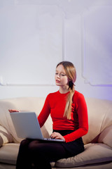 Woman sitting in her living room and using laptop.