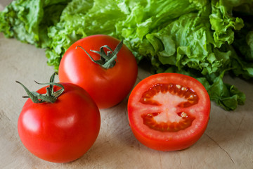 Tomatoes and lettuce on a wooden background.