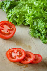 Tomatoes and lettuce on a wooden background.