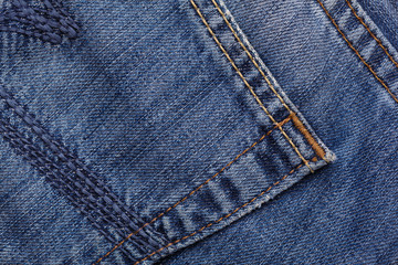 Fototapeta premium Denim jeans texture background with torn. The texture of the colored cotton fabric. Stitched texture jeans background. Fashion jeans button. Pocket and rivet on jeans. Fiber and fabric structure.
