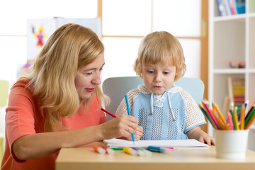 Mother playing with her child son, drawing together
