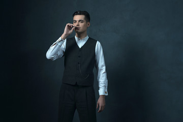 Cigarette smoking retro 1920s english style gangster against gra