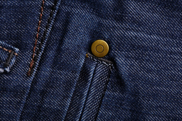 Denim jeans texture background with torn. The texture of the colored cotton fabric. Stitched texture jeans background. Fashion jeans button. Pocket and rivet on jeans. Fiber and fabric structure.
