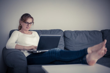 Middle-aged woman using laptop at home