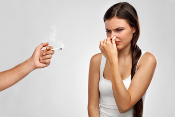 Smoking. Beautiful Woman Holding Nose, Smelling Cigarette Smell