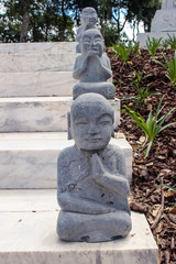 Small stone statues of buddha on the staircase of a temple