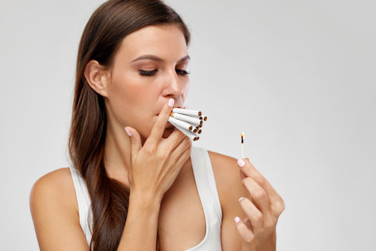 Smoking Cigarette. Woman Lighting Cigarettes With Match