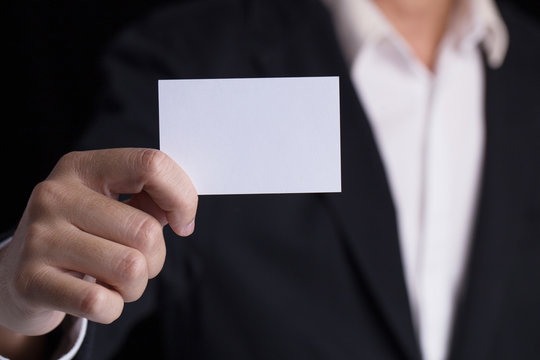 A man in business black suit holding a white blank business card,name card.