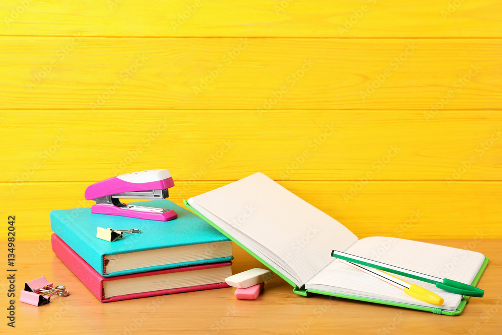 Wall mural Colorful notebooks and accessories on wooden background