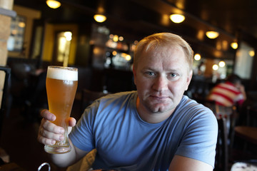 Man posing with glass of beer