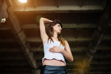 Portrait of young cute brunette girl wearing on black leather pa