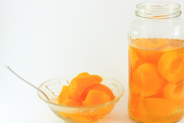 Canned apricots in a glass bottle and a glass bowl