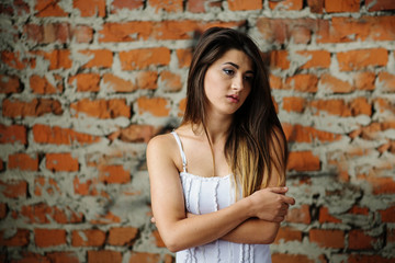 Fototapeta na wymiar Portrait of young cute brunette girl background brick wall.