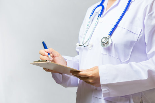 Close up of female medicine doctor  writing on clipboard. Medica