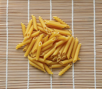 Penne pasta on a bamboo mat.